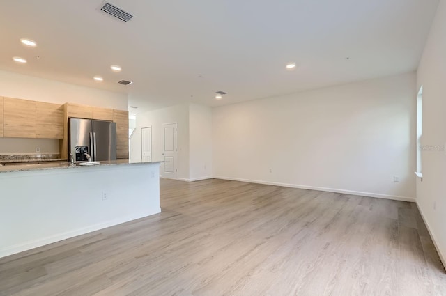 unfurnished living room with light wood-style flooring, baseboards, visible vents, and recessed lighting