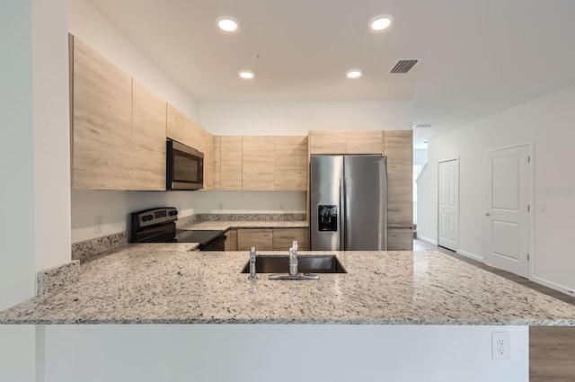 kitchen with light stone counters, recessed lighting, visible vents, stainless steel appliances, and light brown cabinetry
