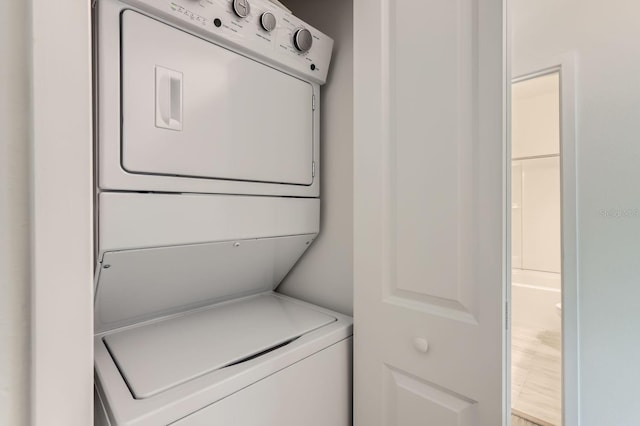 washroom featuring stacked washer / dryer and laundry area