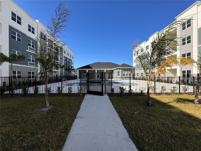 surrounding community featuring a swimming pool, fence, and a yard