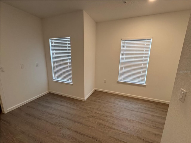 unfurnished room with wood finished floors and baseboards