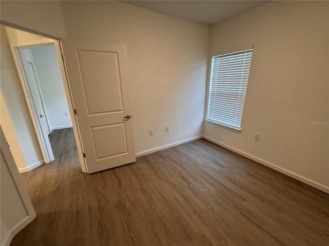 spare room with wood finished floors and baseboards
