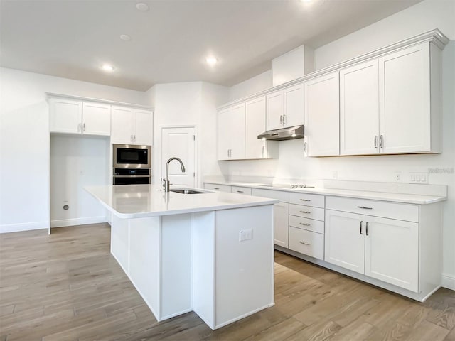 kitchen featuring white cabinetry, sink, and a kitchen island with sink