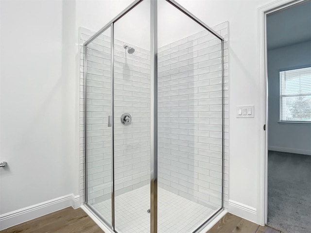 bathroom with hardwood / wood-style flooring and an enclosed shower