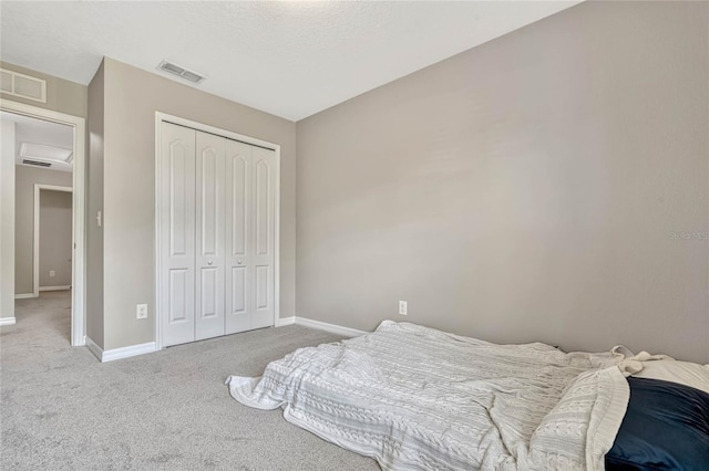 carpeted bedroom with a textured ceiling and a closet
