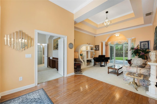 126 Seville Chase Dr, Winter Springs, FL 32708 - living room with ornate columns, arched walkways, light wood finished floors, ornamental molding, and a tray ceiling