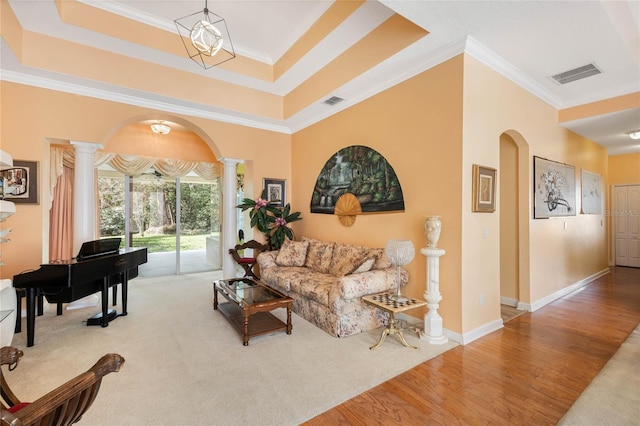 126 Seville Chase Dr, Winter Springs, FL 32708 - living room featuring decorative columns, arched walkways, ornamental molding, wood finished floors, and a raised ceiling