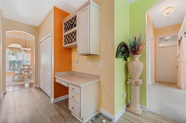 126 Seville Chase Dr, Winter Springs, FL 32708 - corridor with light wood-type flooring, arched walkways, baseboards, and a chandelier