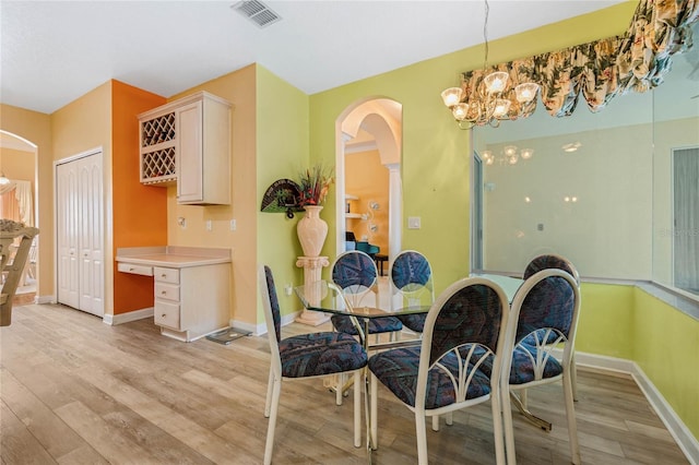 126 Seville Chase Dr, Winter Springs, FL 32708 - dining space with arched walkways, light wood finished floors, and a chandelier