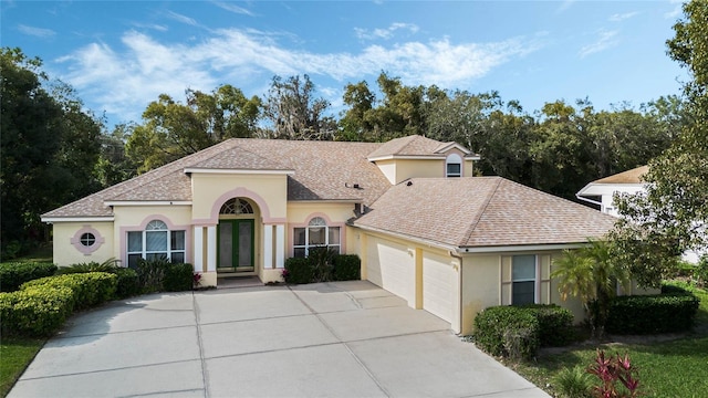 126 Seville Chase Dr, Winter Springs, FL 32708 - mediterranean / spanish house with stucco siding, an attached garage, driveway, and a shingled roof