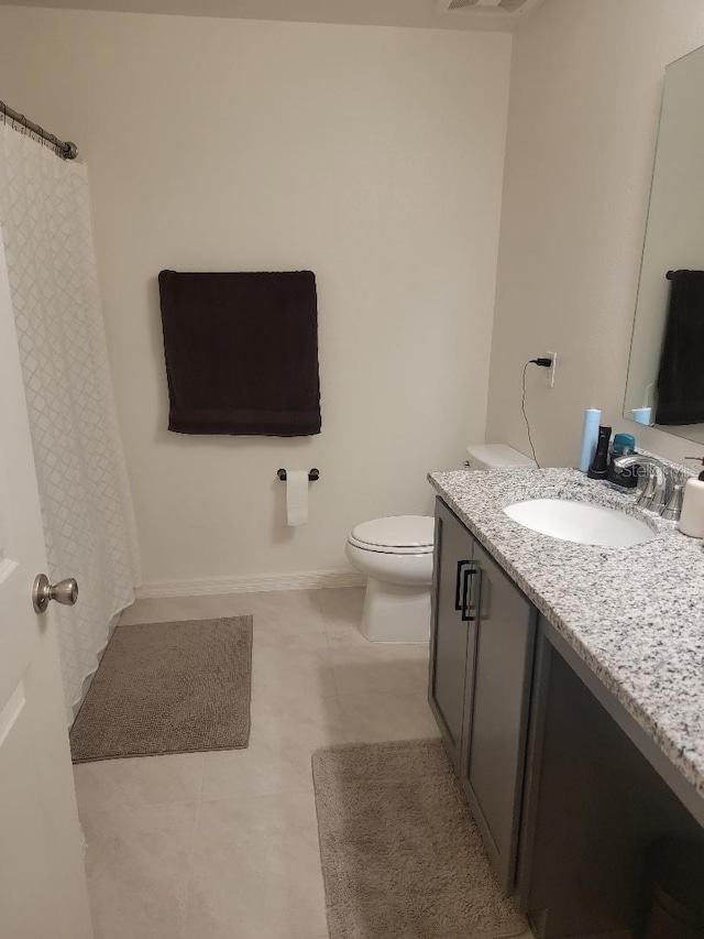 bathroom featuring vanity, toilet, and tile patterned flooring