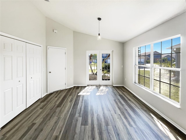 unfurnished dining area with french doors, lofted ceiling, and dark hardwood / wood-style floors