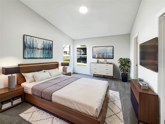 bedroom with dark colored carpet and vaulted ceiling