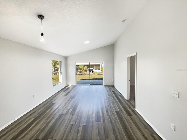 empty room with high vaulted ceiling and dark hardwood / wood-style flooring