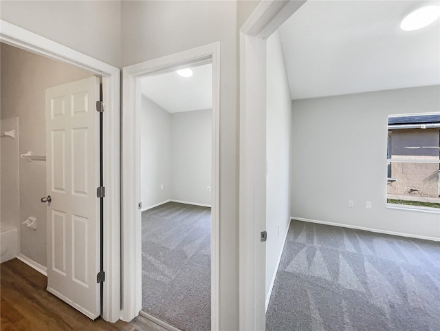 hallway featuring dark colored carpet