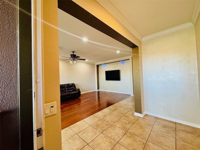 unfurnished living room with tile patterned flooring, crown molding, and ceiling fan