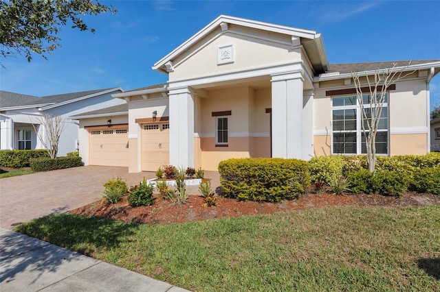 neoclassical / greek revival house with a garage and a front yard