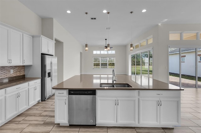 kitchen with sink, white cabinetry, decorative light fixtures, a center island with sink, and appliances with stainless steel finishes