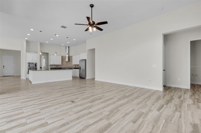 unfurnished living room featuring ceiling fan