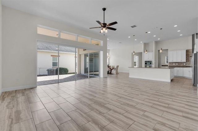 unfurnished living room with ceiling fan