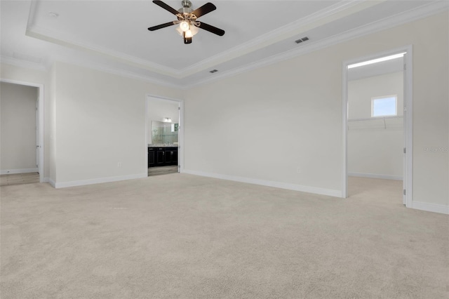 carpeted empty room with crown molding, ceiling fan, and a raised ceiling