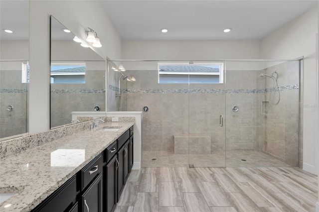 bathroom featuring vanity, a wealth of natural light, and walk in shower