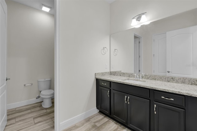 bathroom featuring hardwood / wood-style flooring, vanity, and toilet