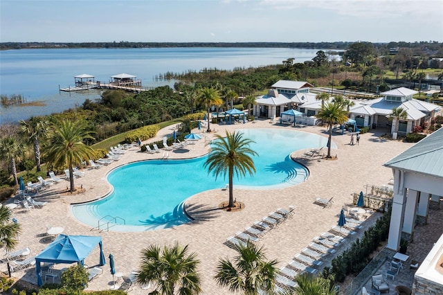 view of swimming pool with a water view and a patio area