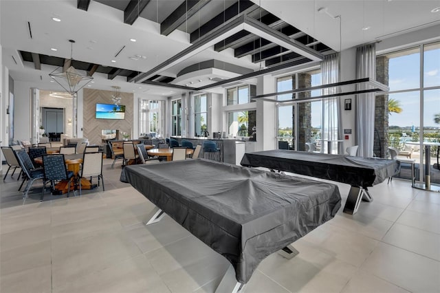 rec room with beamed ceiling, light tile patterned flooring, a high ceiling, and pool table