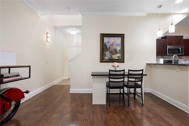 dining area featuring ornamental molding and dark hardwood / wood-style floors