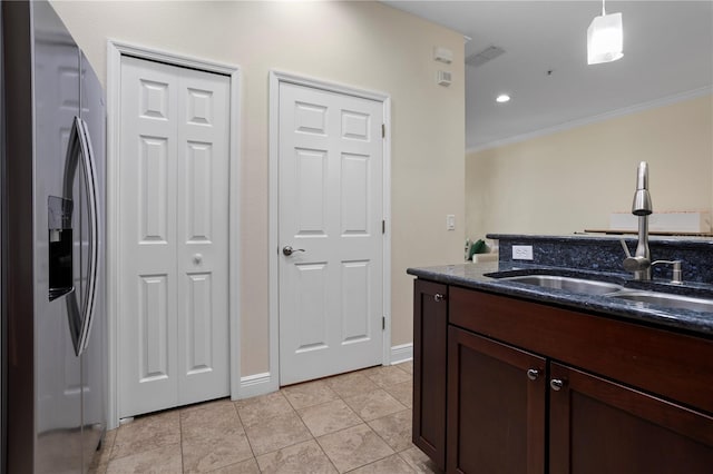 kitchen featuring light tile patterned flooring, pendant lighting, sink, stainless steel refrigerator with ice dispenser, and dark brown cabinets