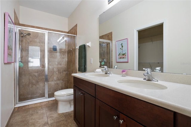 bathroom featuring walk in shower, vanity, toilet, and tile patterned flooring