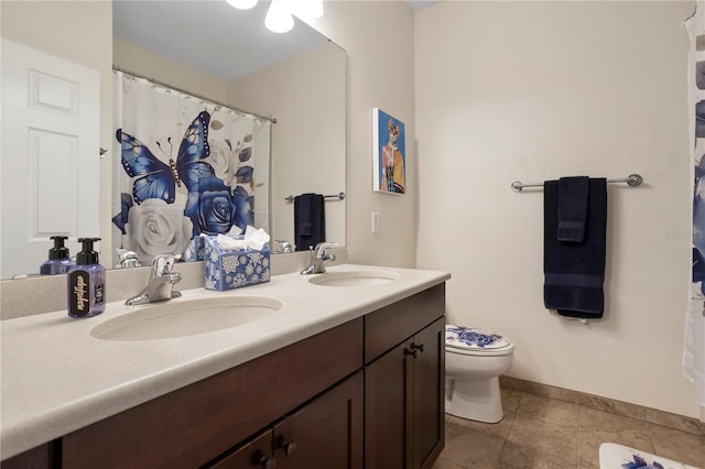 bathroom featuring tile patterned flooring, vanity, and toilet