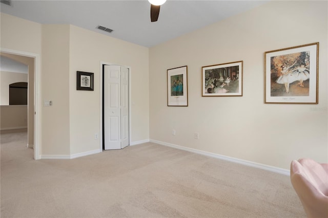 unfurnished bedroom featuring light colored carpet, a closet, and ceiling fan