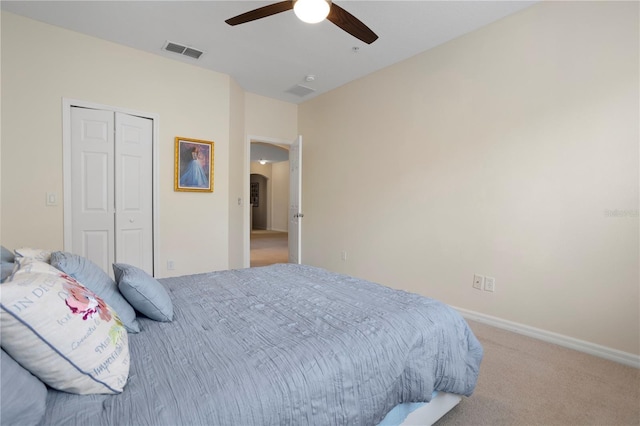 carpeted bedroom with ceiling fan and a closet