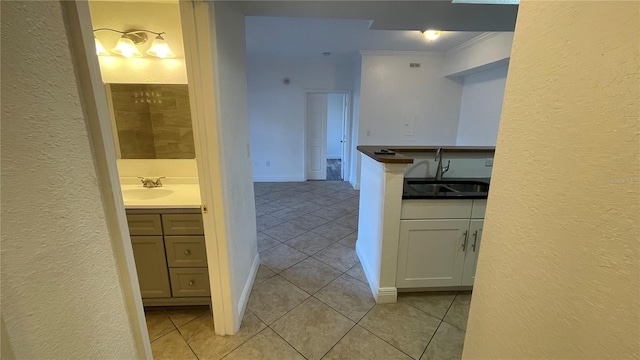 bathroom featuring tile patterned flooring, vanity, and crown molding