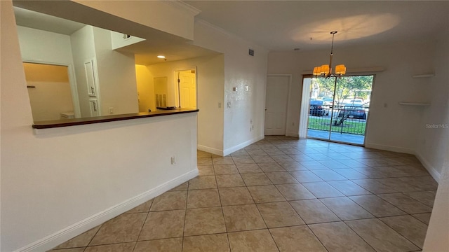 empty room with light tile patterned flooring and a chandelier