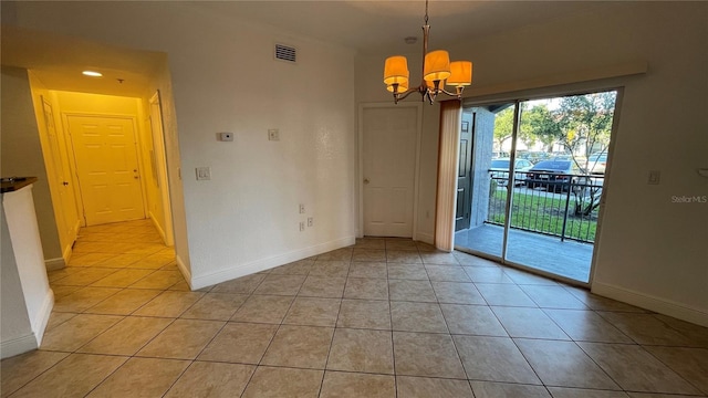 unfurnished dining area featuring light tile patterned floors and a notable chandelier