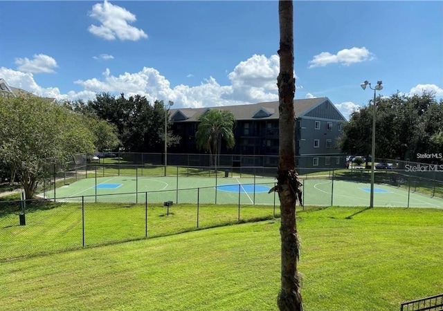 view of sport court with a yard and basketball hoop