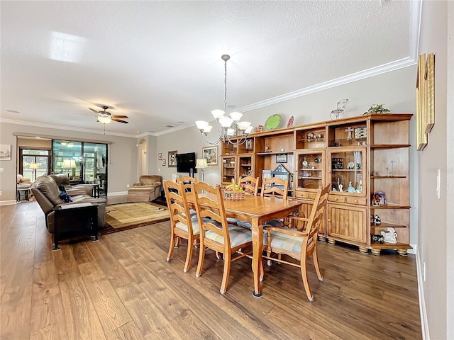 dining space featuring crown molding, ceiling fan with notable chandelier, a textured ceiling, and hardwood / wood-style flooring