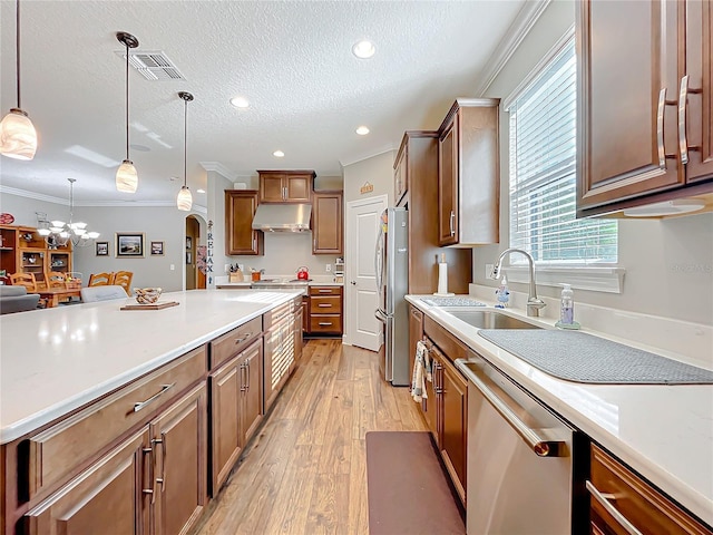 kitchen featuring crown molding, appliances with stainless steel finishes, decorative light fixtures, and sink