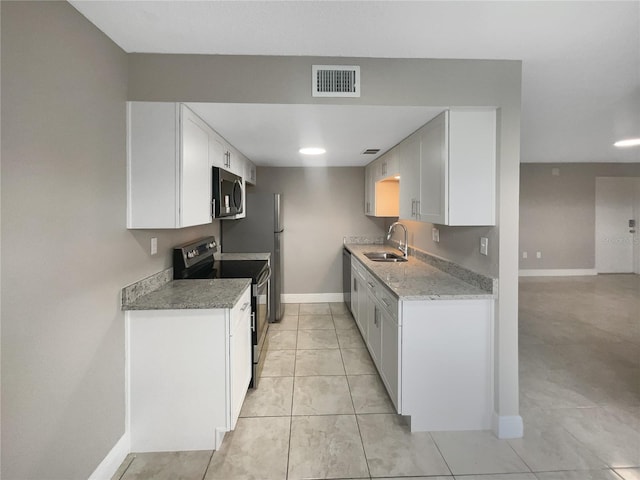 kitchen featuring white cabinetry, sink, light tile patterned floors, stainless steel appliances, and light stone countertops