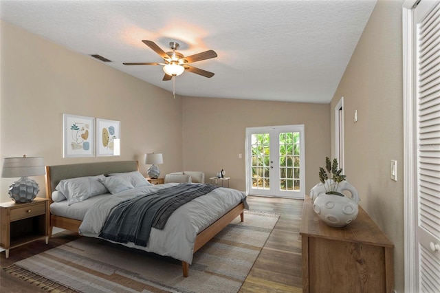 bedroom with lofted ceiling, dark hardwood / wood-style flooring, ceiling fan, a textured ceiling, and french doors