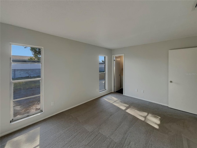 unfurnished room with dark carpet