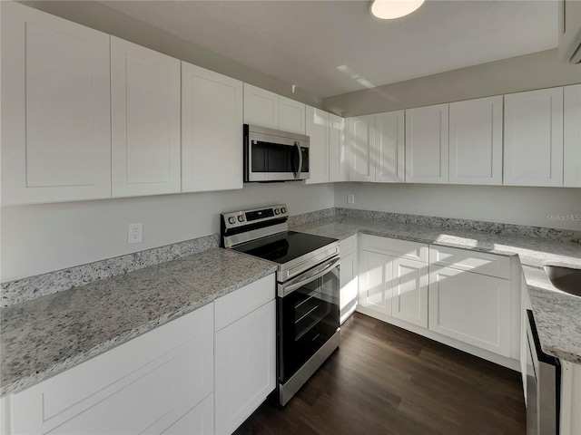 kitchen featuring white cabinetry, appliances with stainless steel finishes, dark hardwood / wood-style floors, and light stone counters