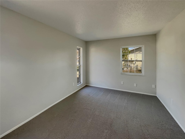 carpeted spare room featuring a textured ceiling