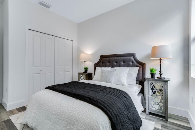 bedroom with light hardwood / wood-style floors and a closet