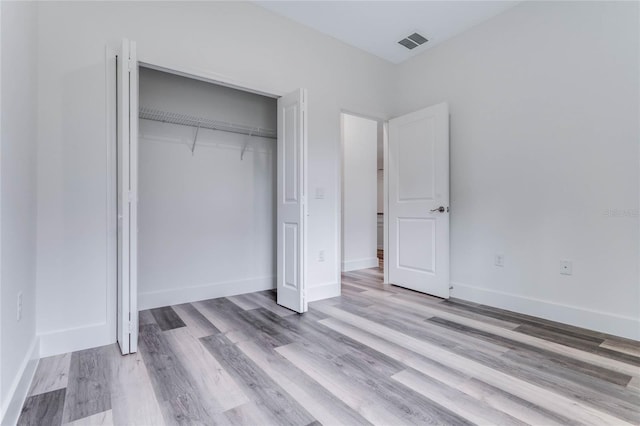 unfurnished bedroom featuring light hardwood / wood-style flooring and a closet