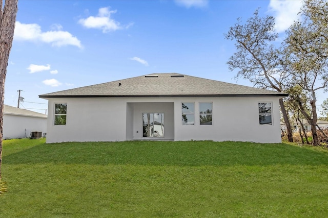 back of house with central AC and a lawn