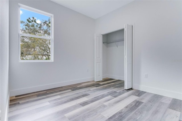 unfurnished bedroom featuring a closet and light hardwood / wood-style flooring